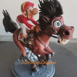 May include: A whimsical figurine of a jockey riding a brown horse in a race. The jockey wears a red and yellow helmet and a red shirt. The horse has a wide-eyed expression and a white number "5" on its saddle. The base has the text "3dbarisatölyesi".