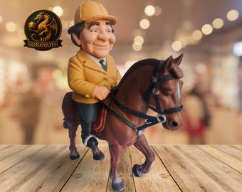 May include: A figurine of a man riding a brown horse. The man is wearing a yellow jacket, a tan riding helmet, and black pants. The horse has a black bridle and saddle. The figurine is on a wooden surface.