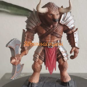 Könnte beinhalten: Eine braune Minotaurus-Figur mit muskulösem Körperbau, die silberne Rüstung und einen roten Lendenschurz trägt. Sie hält eine silberne und bronzefarbene Axt. Die Figur hat große Hörner und steht auf einem grauen Sockel.