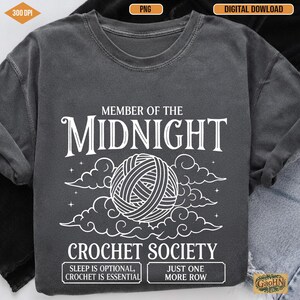 Może przedstawiać: Ciemnoszara bluza z białym napisem: "MEMBER OF THE MIDNIGHT CROCHET SOCIETY". Projekt zawiera kulę przędzy, chmury oraz frazy "SLEEP IS OPTIONAL, CROCHET IS ESSENTIAL" i "JUST ONE MORE ROW."