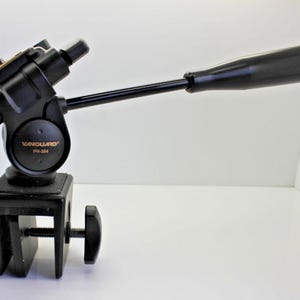 May include: Black Vanguard PH-304 tripod head with a clamp base and a long, black handle. The head has a ball joint for adjusting the angle. The product is designed for photography and videography.