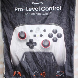 May include: A white and black banner featuring a Nintendo Switch controller. The controller has red accents around the joysticks and buttons. Text on the banner reads "FUSION Pro-Level Control For Nintendo Switch". Additional text indicates mappable pro pack, wired or wireless, and swappable parts.