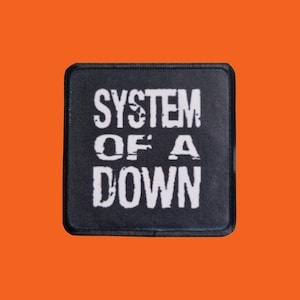 Könnte beinhalten: Schwarzer quadratischer Aufnäher mit dem Schriftzug "SYSTEM OF A DOWN" in verblichenen weißen Buchstaben. Der Aufnäher hat einen schwarzen Rand und einen orangefarbenen Hintergrund.