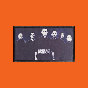 Op de afbeelding: Een rechthoekige patch met zes mensen in donkere kleding tegen een donkere achtergrond. De bandnaam "LINKIN PARK" is in het wit gedrukt, samen met een gestileerd symbool.