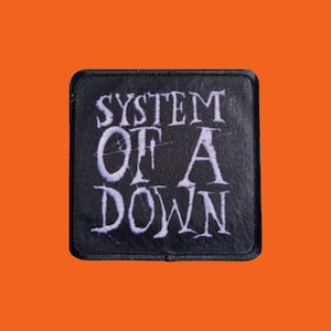 Könnte beinhalten: Ein schwarzer quadratischer Aufnäher mit dem weißen Text "SYSTEM OF A DOWN". Der Text ist in einer stilisierten Schriftart gehalten. Der Aufnäher hat einen schwarzen Rand und ist vor einem orangefarbenen Hintergrund platziert.