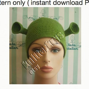 May include: A green crocheted hat with ear-like protrusions, resembling a character from a popular animated film. The hat is displayed on a mannequin head. Text at the top reads "Pattern only (instant download PDF)". The Etsy shop name "KnitterKits" is also visible.