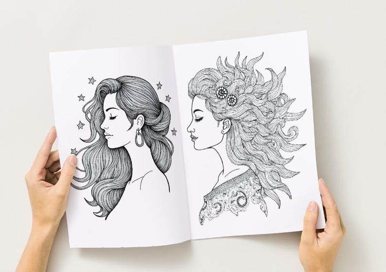 Peut inclure: Une double page d'un livre de coloriage avec deux illustrations d&eacute;taill&eacute;es en noir et blanc de profils de femmes. L'une a des cheveux fluides avec des &eacute;toiles, l'autre a des cheveux &eacute;labor&eacute;s avec des &eacute;l&eacute;ments d&eacute;coratifs. Le livre est ouvert.