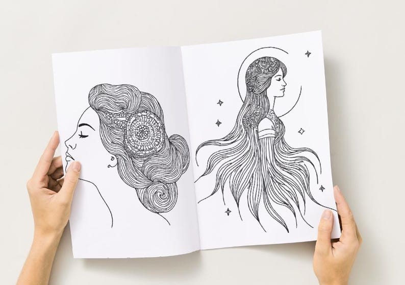 Peut inclure: Livre ouvert avec deux illustrations en noir et blanc de visages de femmes. L'une a des cheveux complexes et un motif circulaire. L'autre a de longs cheveux fluides, un halo et des &eacute;toiles. Le livre est tenu ouvert par des mains.