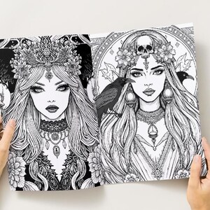 Puede incluir: Doble p&aacute;gina de ilustraciones en blanco y negro con retratos detallados de mujeres con cabello largo, coronas de flores y joyas ornamentadas. Una ilustraci&oacute;n incluye un cuervo. La obra de arte est&aacute; sostenida por manos sobre un fondo blanco.