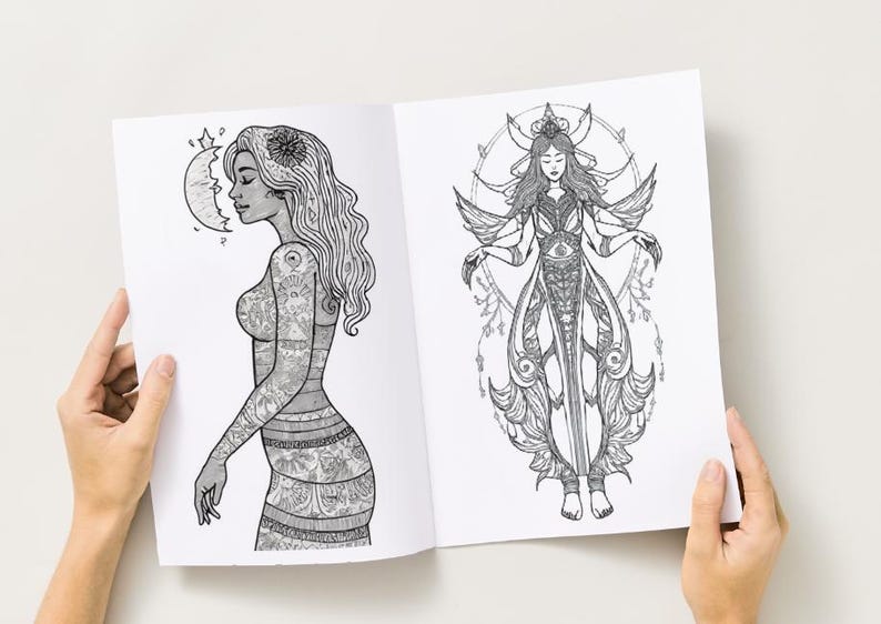Peut inclure: Livre ouvert avec deux illustrations d&eacute;taill&eacute;es en noir et blanc. L'une repr&eacute;sente une femme tatou&eacute;e, un croissant de lune et une fleur dans les cheveux. L'autre montre une femme ail&eacute;e avec un design orn&eacute;.