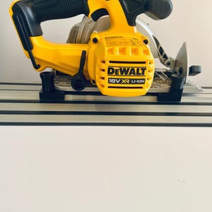 May include: A yellow and black DeWalt 18V XR Li-Ion circular saw. The saw features a black handle and a silver blade. The saw is designed for cutting wood and other materials.