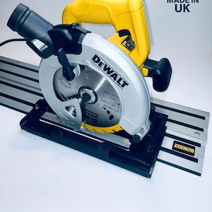 May include: A silver and yellow DEWALT circular saw with a black base and guide rail. The saw blade is visible, and the text "Adapter Only" is at the bottom. Made in UK.