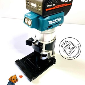 Könnte beinhalten: Ein türkis-schwarzer Makita Akku-Fräser mit einem schwarzen Akkupack. Der Akkupack trägt die Aufschrift "5.5Ah" und "18V Li-ion". Das Bild enthält auch den Text "PrintForgeArt" und "I Love PrinForge Art".