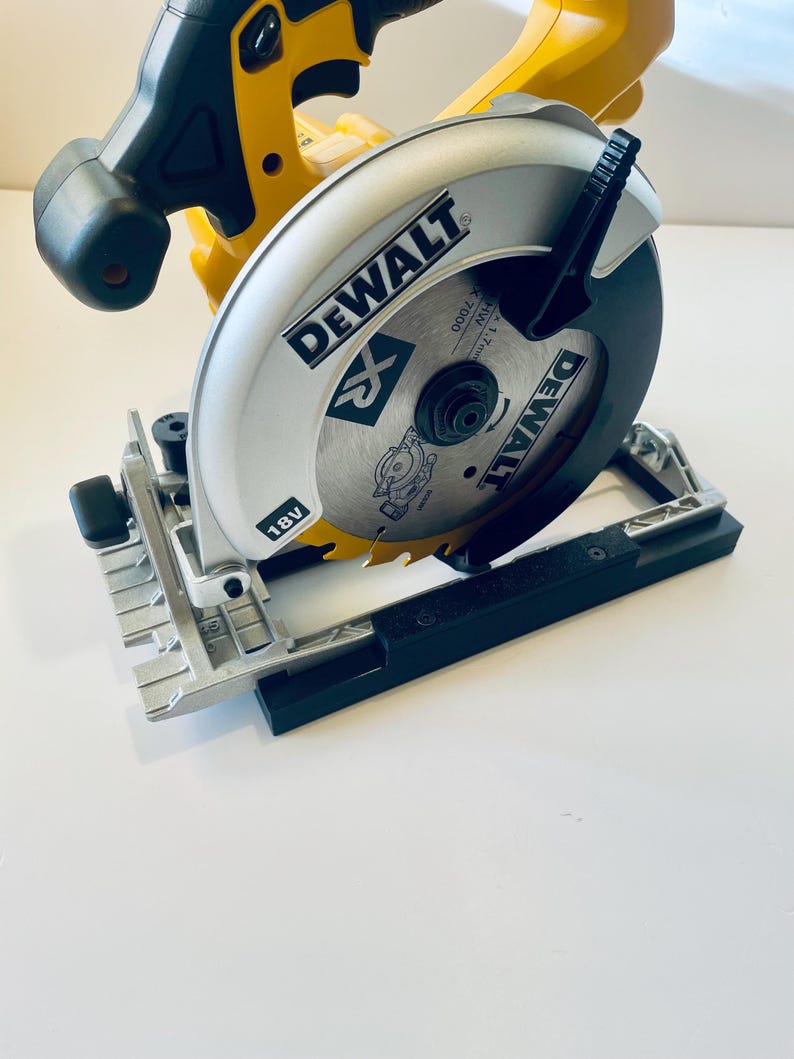 May include: A yellow and black DeWalt 18V circular saw. The saw blade is silver with the DeWalt logo and a black guard. The saw is designed for cutting wood and other materials. The saw is on a white surface.