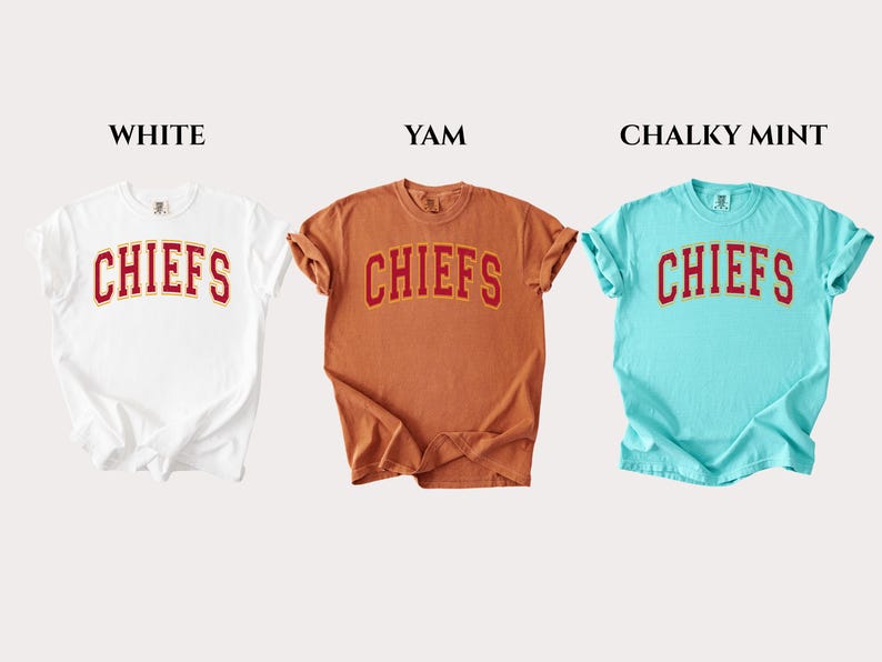 Op de afbeelding: Drie T-shirts met korte mouwen en ronde hals in de kleuren wit, yam en chalky mint. Elk shirt heeft het woord CHIEFS in een rood gebogen lettertype met een gele omlijning op de borst. De labels WHITE, YAM en CHALKY MINT staan erboven afgebeeld.