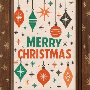 Puede incluir: Obra de arte en punto de cruz enmarcada con temática navideña. El diseño presenta adornos colgantes en naranja, verde y negro, junto con copos de nieve y las palabras "MERRY CHRISTMAS" en verde y naranja. El marco es marrón con detalles dorados de copos de nieve.