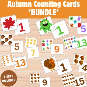 Peut inclure: Ensemble de cartes de comptage sur le thème de l'automne avec des chiffres et des illustrations de feuilles, de glands, de dindes et de monstres. Les cartes sont disposées sur une surface en bois et comprennent le texte "Autumn Counting Cards *BUNDLE*" et "3 SETS INCLUDED".