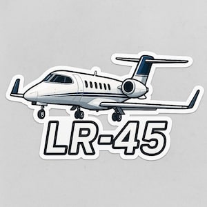 May include: A white and blue LR-45 jet sticker. The sticker features a detailed illustration of a private jet with black accents and the text "LR-45" in bold, black letters.