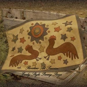 May include: A tan penny rug with a sun and star design, featuring two brown rooster silhouettes. The rug has a dark border and the text "Roosters At Sunrise" and "Early Style Penny Rugs".