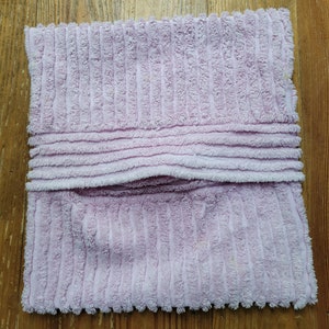 May include: A soft, pink, corduroy pillow with a seam down the middle.