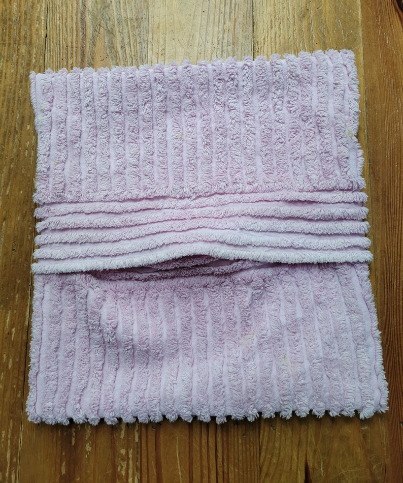 May include: A soft, pink, corduroy pillow with a seam down the middle.