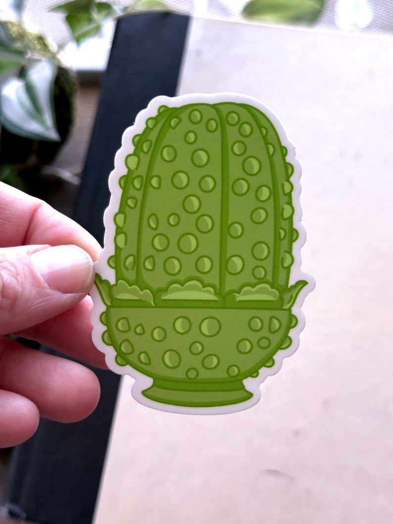 May include: Green cartoon sticker of a plant with a bulbous, round, textured body and a green, scalloped, bowl-shaped base.