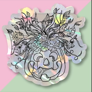 May include: A holographic sticker featuring a black line drawing of a Halloween pumpkin with a floral arrangement and spiderwebs. The pumpkin has a smiling face and is surrounded by leaves and flowers. The background is pink and green.