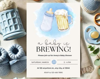 May include: A baby shower invitation with a watercolor illustration of a baby bottle and a beer mug. The invitation reads "a baby is BREWING!" with event details. Blue baby booties, a pacifier, and pretzels surround the invitation.