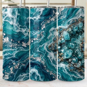 Peut inclure: Trois gobelets en acier inoxydable avec un motif abstrait turquoise et blanc. Le motif comprend des accents de feuilles d'argent et un motif en forme de cristal sur un gobelet. Chaque gobelet a une paille argentée.