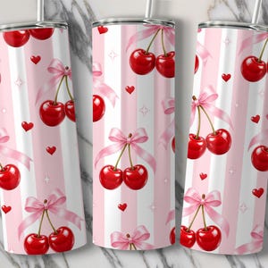 May include: Tumblers with a repeating pattern of red cherries tied with pink bows, small red hearts, and white stars on a pink and white striped background. The tumblers have a silver rim and a straw.