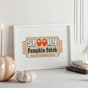 May include: A white framed print featuring a ticket-shaped graphic with the text "SPOOKY PUMPKIN PATCH" and "Hagrid's Pumpkin Farm". The design includes orange jack-o'-lantern icons and "ADMIT ONE" text on a light peach background.
