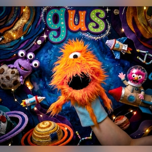 May include: An orange fuzzy monster hand puppet with one eye and a wide open mouth, positioned in front of a space-themed backdrop featuring the text gus, a purple three-eyed alien, a pink astronaut puppet in a rocket, and felt planets.