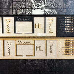 Peut inclure: Deux plateaux de jeu en bois avec des sections découpées au laser étiquetées "AI", "Discard", "Wound" et "HL". Un plateau est sombre, l'autre est clair. Chaque plateau a une section avec des valeurs numériques pour les statistiques du jeu.