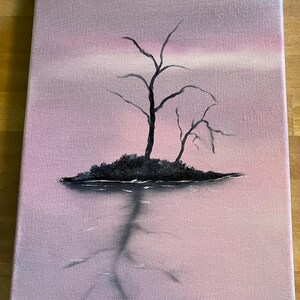 May include: A canvas painting depicts a serene landscape. Silhouetted black trees stand on a small island, reflected in the water below. The sky transitions from a soft pink to a lighter hue, creating a tranquil atmosphere. The artwork is mounted on a wooden easel.