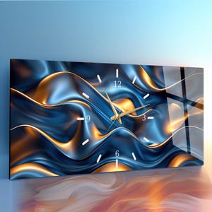 Puede incluir: Reloj de pared rectangular con un diseño abstracto azul y dorado. La esfera del reloj presenta marcadores de hora blancos y manecillas doradas. El fondo tiene un patrón ondulado y fluido con un acabado brillante.
