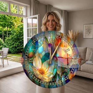 May include: A large circular wall clock featuring a vibrant stained glass design with multi-coloured floral patterns in shades of blue, teal, orange, and yellow. The clock face displays gold-coloured Roman numerals and thin gold clock hands.