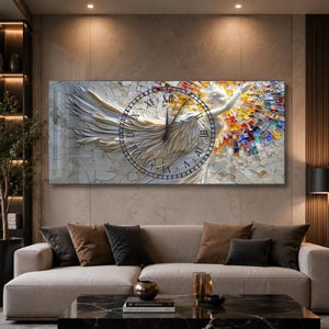 May include: A rectangular wall clock featuring a central circular dial with black Roman numerals. The clock face displays a detailed graphic of a winged figure with white feathers on the left and a vibrant, multi-colored mosaic pattern on the right.