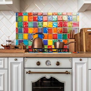 May include: A kitchen with a vibrant, multi-coloured tiled splashback. A copper kettle and saucepan are on the hob. White cabinets and a wooden worktop are also visible, creating a bright and inviting space.