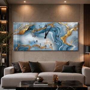 Puede incluir: Un reloj de pared rectangular con un patrón de mármol azul y blanco con vetas doradas. La esfera muestra números arábigos negros del 1 al 12 dispuestos en círculo, con manecillas negras para las horas y los minutos en el centro.