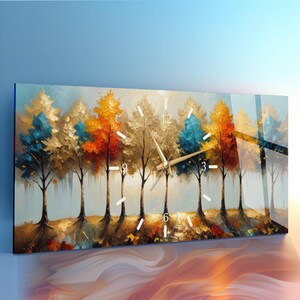 May include: A rectangular wall clock featuring a vibrant landscape painting of a forest with trees in shades of blue, gold, orange, and red. The clock face has white hour markers and gold-toned hands centered over the painted tree trunks.