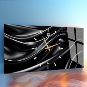 May include: A rectangular wall clock with a black and silver abstract design. The clock face has white hour markers and gold-colored hands. The background features a flowing, rippled pattern.