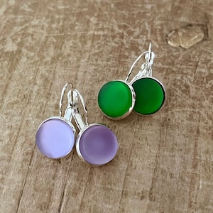 May include: A pair of silver clip-on earrings with round green and purple glass stones.