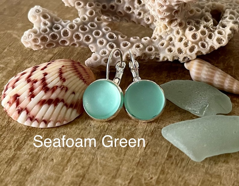 May include: Seafoam green glass earrings with silver hooks. The earrings are round and have a frosted finish.