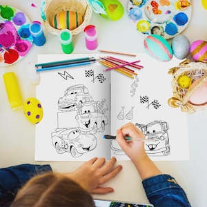 May include: A coloring book open to a Cars-themed illustration, with a hand coloring the image. Colored pencils and paint supplies surround the book. Easter eggs and a basket are also visible.