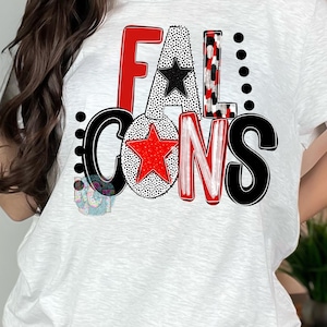 May include: White t-shirt featuring the text "FALCONS" in a bold, colorful design. The letters are in red, black, and white with star accents. The shirt has a crew neck and short sleeves.