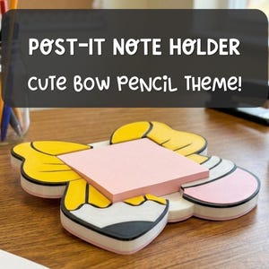May include: A flat, bow-shaped desk accessory featuring a yellow and white design with a pink square sticky note pad centered on top. The text POST-IT NOTE HOLDER CUTE BOW PENCIL THEME! is displayed above the object in a dark gray overlay box.