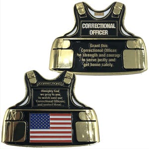 May include: Two metal coins shaped like a bulletproof vest. One coin reads "Correctional Officer" with a prayer. The other coin has an American flag and the word "Corrections". Both coins have gold and black accents.