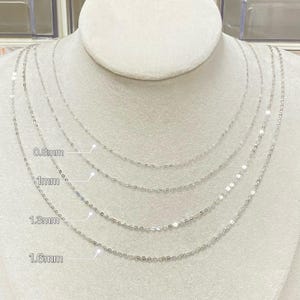 Peut inclure: Quatre colliers argent&eacute;s d&eacute;licats de diff&eacute;rentes &eacute;paisseurs sont pr&eacute;sent&eacute;s sur un buste de mannequin blanc. Les colliers sont &eacute;tiquet&eacute;s avec leurs largeurs : 0,8 mm, 1 mm, 1,3 mm et 1,6 mm. Les cha&icirc;nes sont fines et semblent &ecirc;tre en m&eacute;tal brillant.