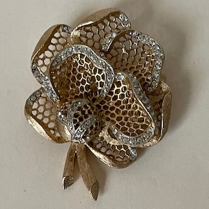 Kramer brushed gold tone metal, clear rhinestone flower brooch