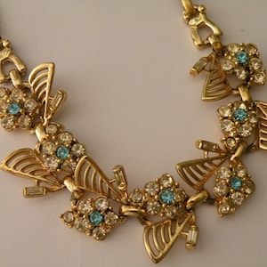 Gold tone metal,  blue, clear rhinestone flower necklace. Unmarked Coro.